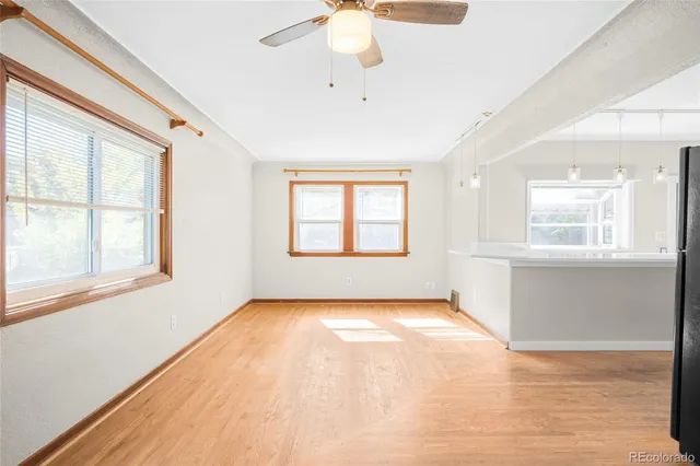 a view of an empty room with a window and wooden floor