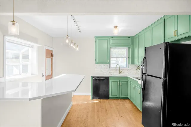 a kitchen with kitchen island a refrigerator stove and sink