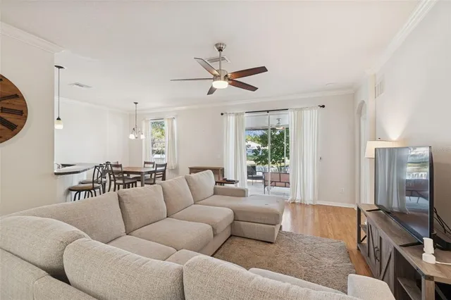 a kitchen with stainless steel appliances granite countertop a stove top oven a sink a dining table and chairs with wooden floor