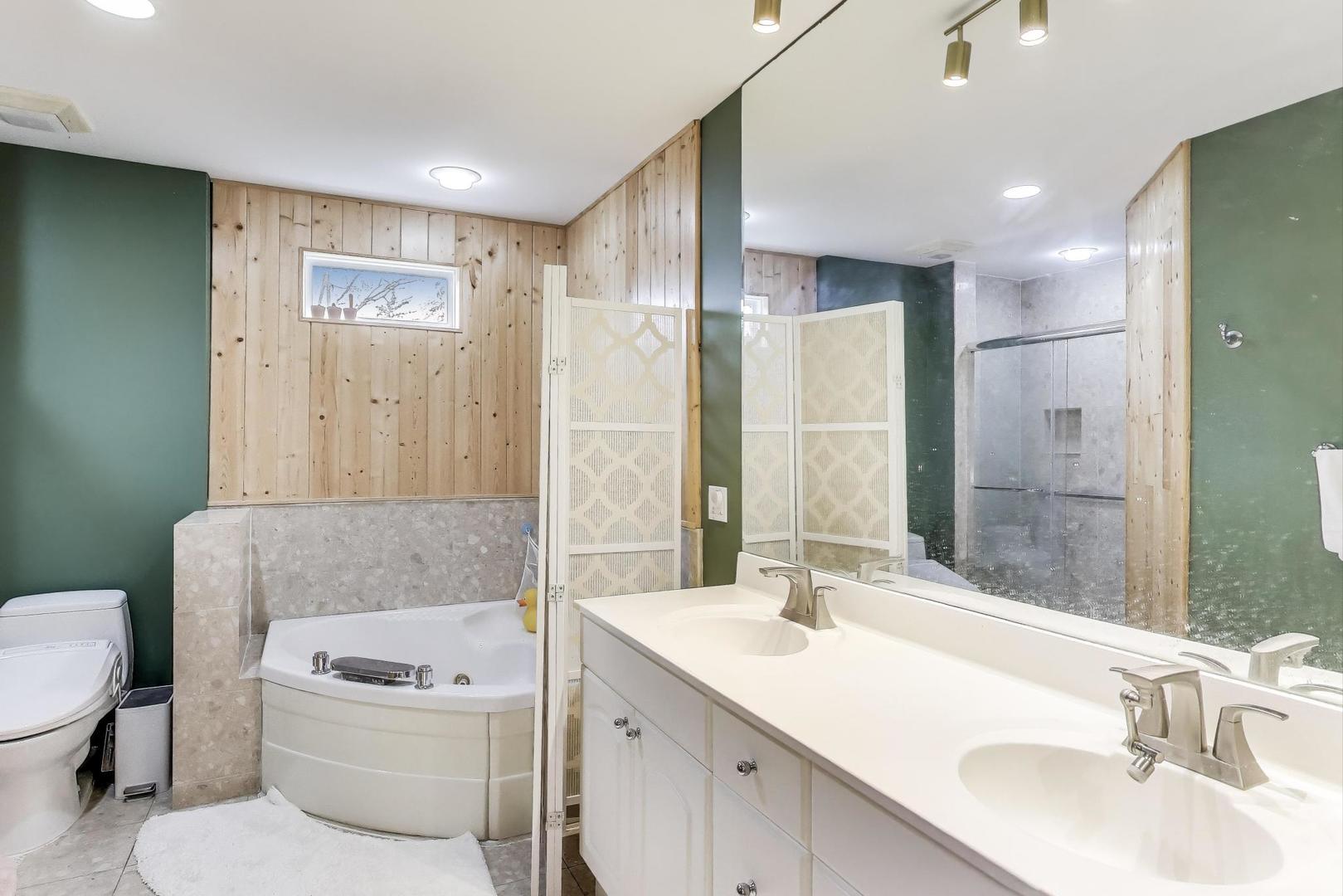 1344 Southwind Drive Northbrook, IL 60062 - Photo 16 of 39 a bathroom with a granite countertop sink a toilet a mirror and shower