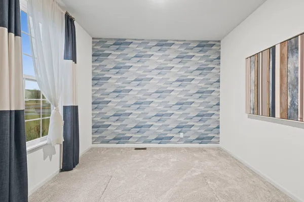 an empty room with windows and fireplace