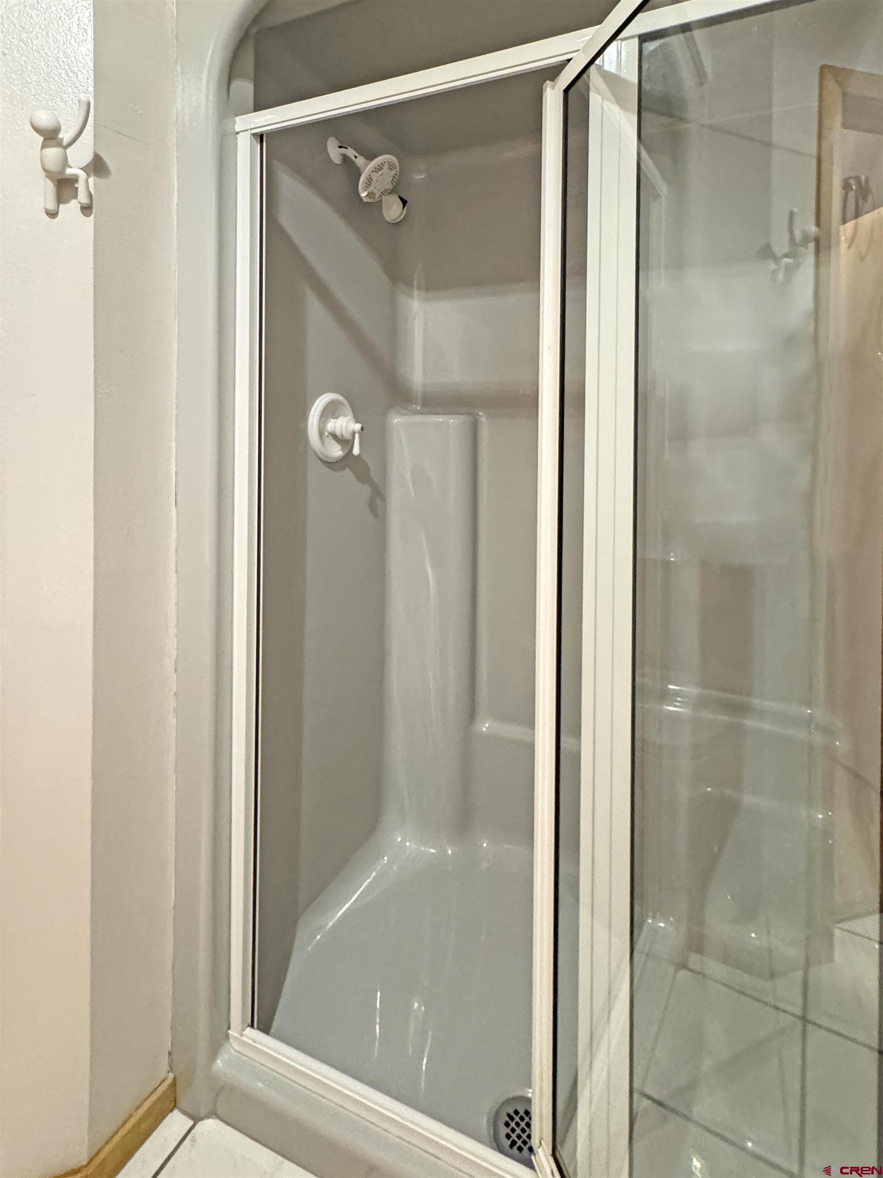 219 Edith Street Cortez, CO 81321 - Photo 24 of 29 a bathroom with a glass shower door and a bathtub