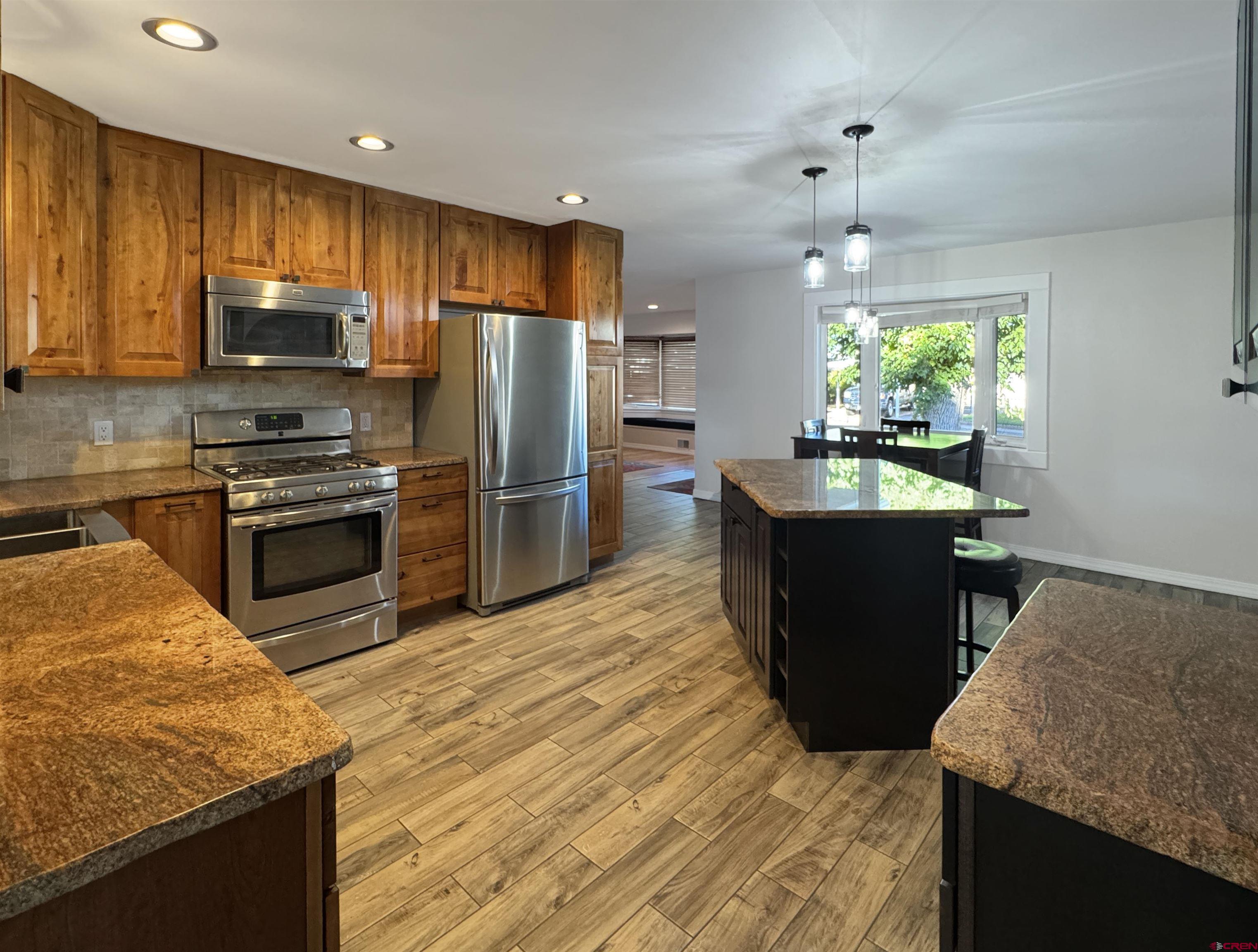 219 Edith Street Cortez, CO 81321 - Photo 10 of 29 a kitchen with kitchen island granite countertop a sink stove and refrigerator