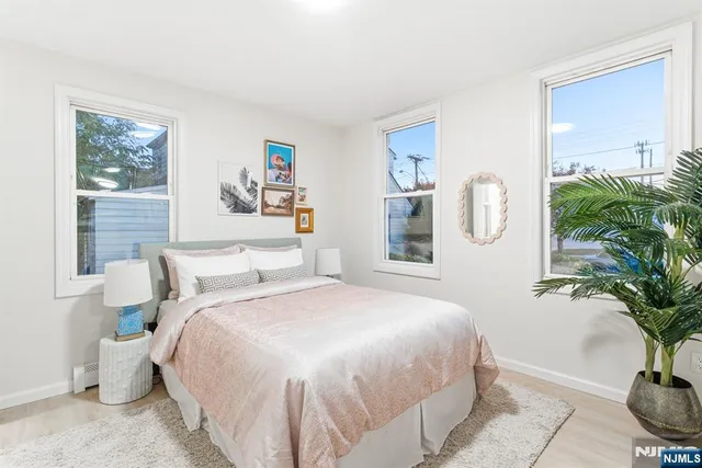 a bedroom with a large bed and a potted plant