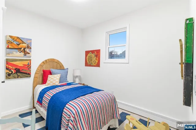 a bedroom with a bed and painting on the wall