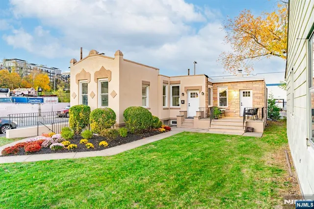 a front view of a house with swimming pool and furniture