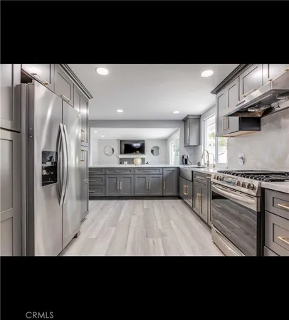 a view of kitchen with stainless steel appliances wooden floor
