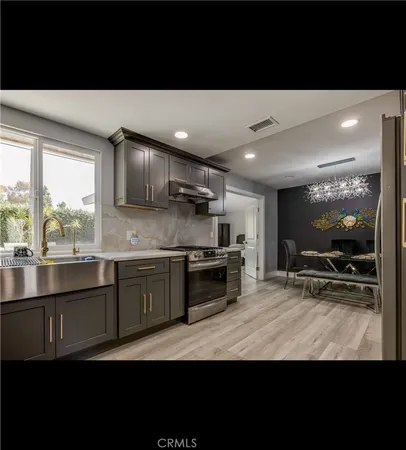 a kitchen with stainless steel appliances a sink stove and cabinets