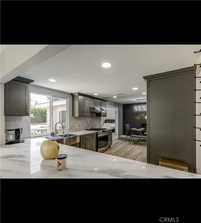 a kitchen with kitchen island granite countertop a sink a stove and cabinets