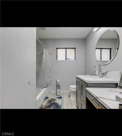 a view of a bathroom with toilet sink and a mirror