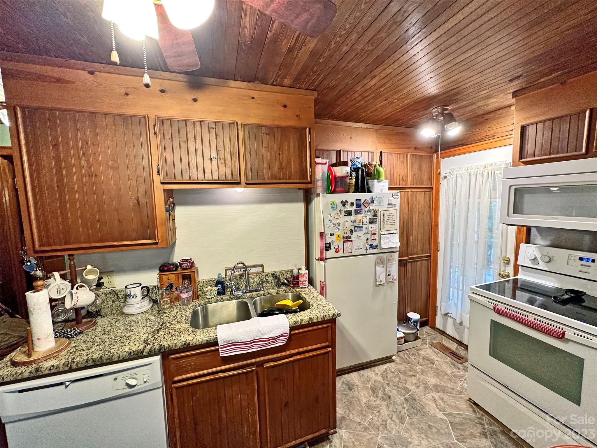 1151 Carpenters Grove Church Road Lawndale, NC 28090 - Photo 11 of 46 a kitchen with stainless steel appliances granite countertop a refrigerator a sink dishwasher a stove and white countertops with wooden floor
