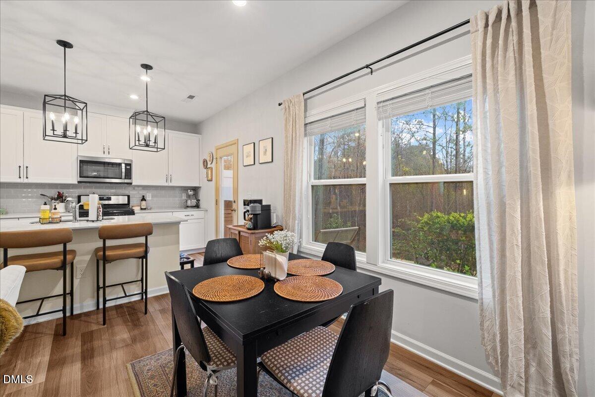 845 Oak Center Drive Raleigh, NC 27610 - Photo 14 of 29 a kitchen with a table chairs stove and wooden floor