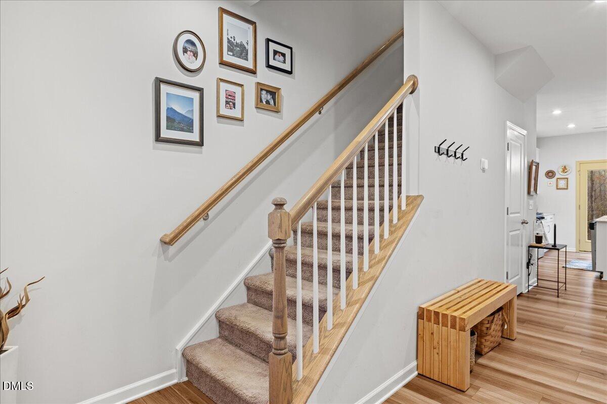 845 Oak Center Drive Raleigh, NC 27610 - Photo 16 of 29 a view of staircase with lots of frames on wall and a wall painting