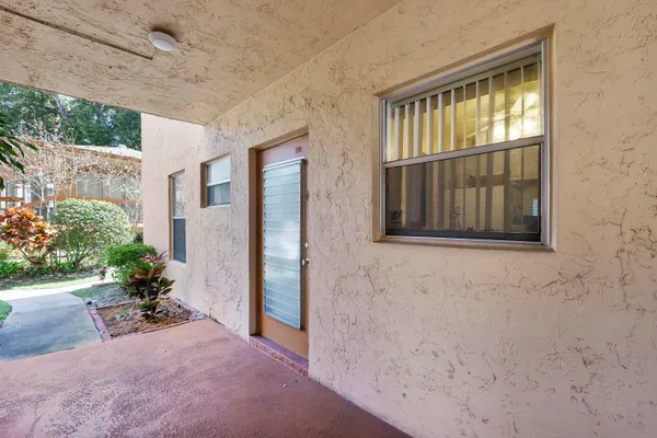 a view of a dining room and livingroom with furniture large windows and a chandelier