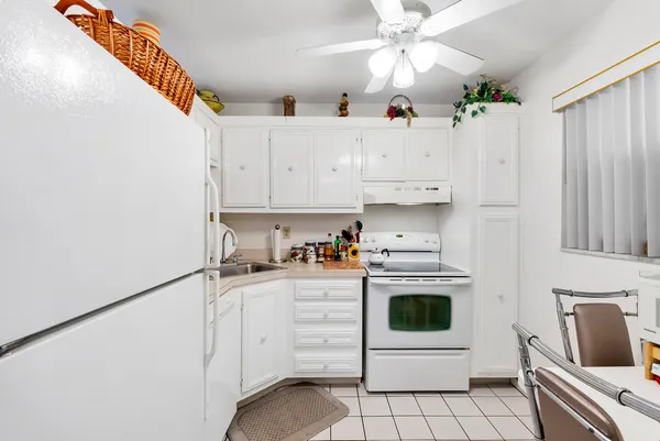 a kitchen with white cabinets and appliances