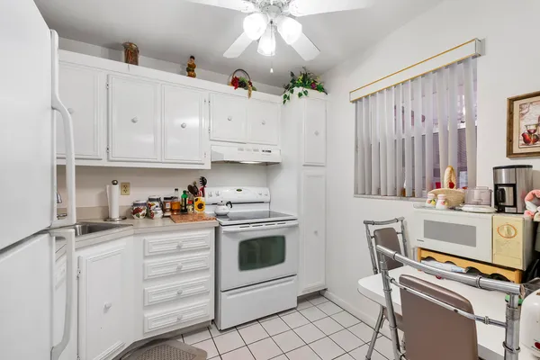 a kitchen with white cabinets and appliances