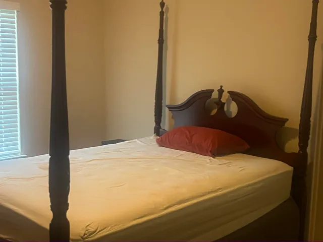 a bedroom with a bed and a window