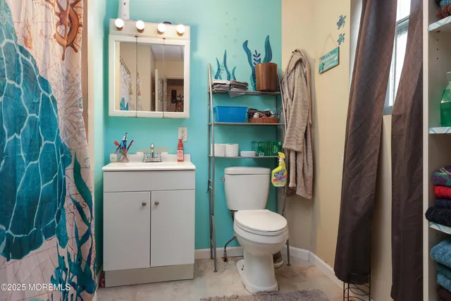 a bathroom with a toilet sink and mirror