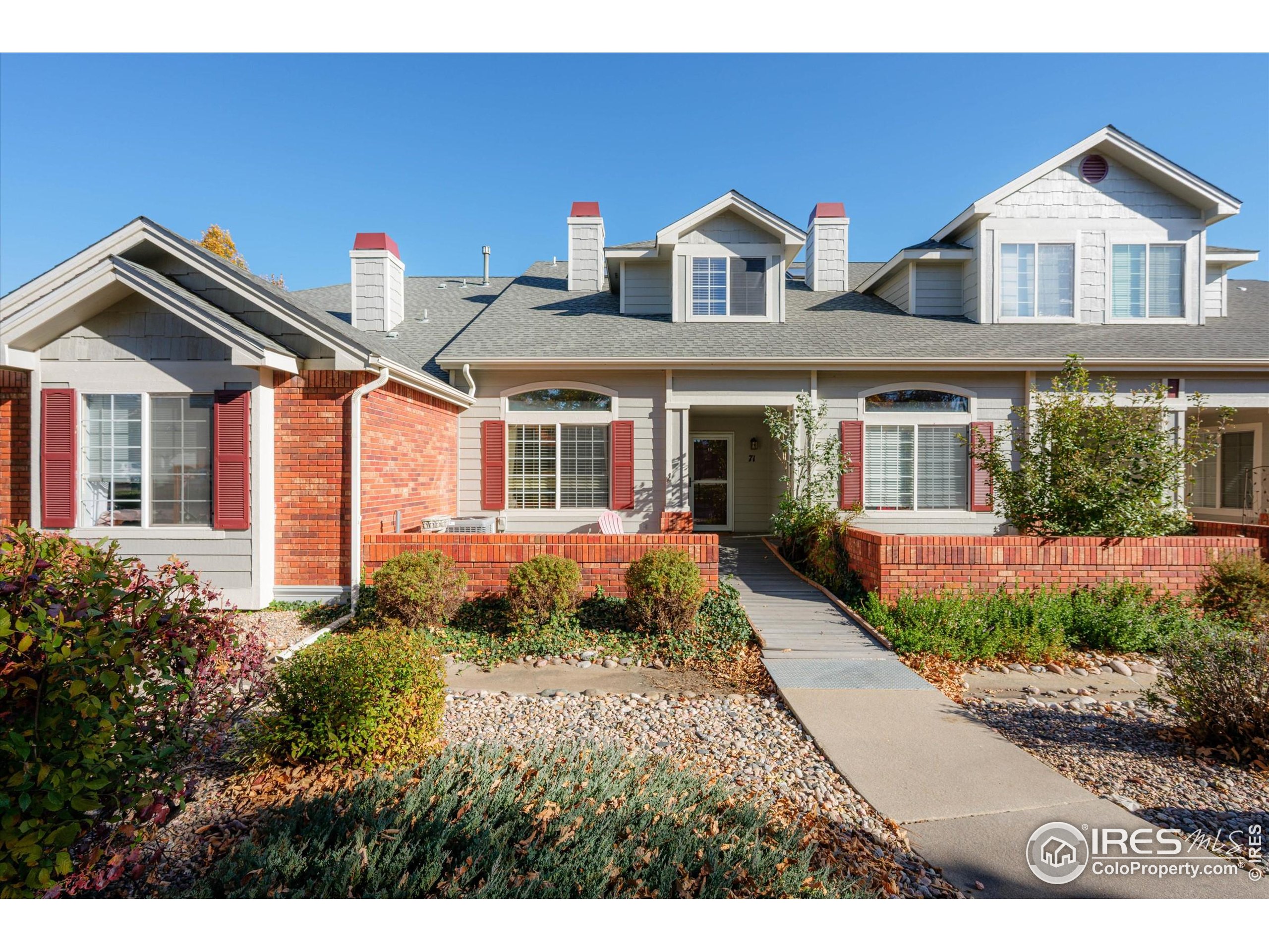 a front view of a house with a yard and potted plants