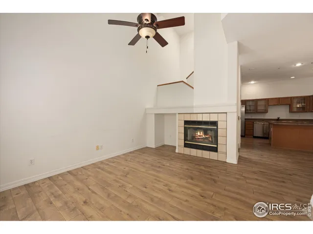 a view of empty room with kitchen and fireplace