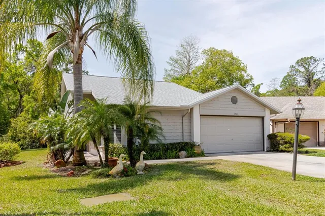 a view of a house with a yard and palm trees