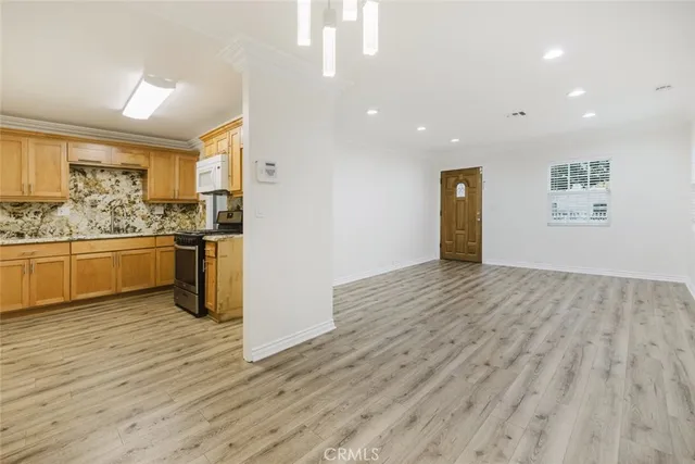 a view of a kitchen with stainless steel appliances granite countertop a refrigerator and a stove top oven