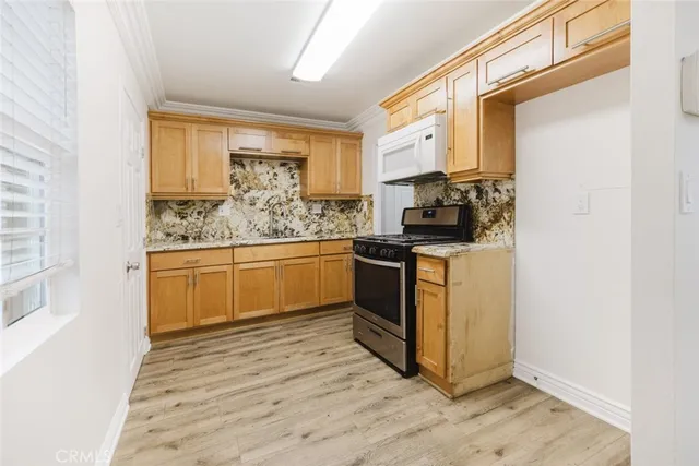 a kitchen with stainless steel appliances granite countertop a stove a sink and a microwave