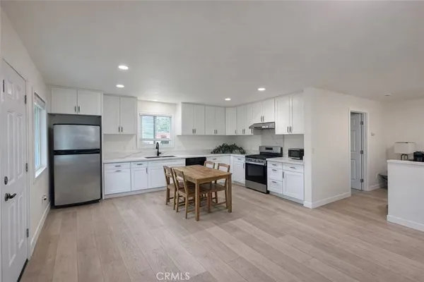 a kitchen with white cabinets and stainless steel appliances