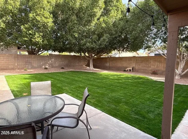 a view of a table and chairs in backyard