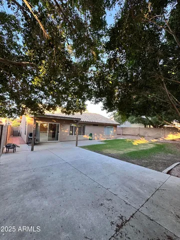 a view of a house with backyard and a tree