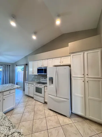a kitchen with a refrigerator and a stove top oven
