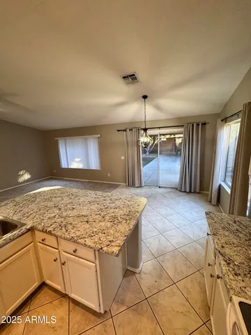 a view of a kitchen with stainless steel appliances granite countertop a sink and cabinets