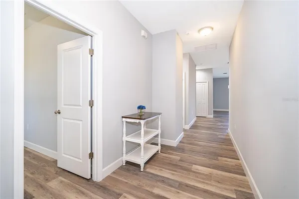 a view of a hallway with wooden floor and closet