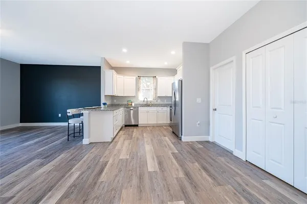 a view of a kitchen with wooden floor electronic appliances and window