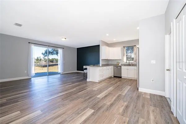 a view of a kitchen with wooden floor and electronic appliances