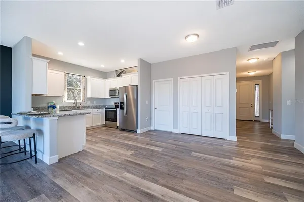 a view of kitchen with granite countertop cabinets and refrigerator