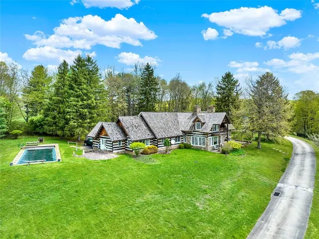 a view of a swimming pool with lawn chairs and a big yard