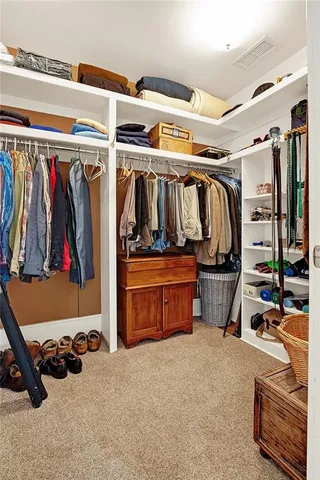 a view of walk in closet with clothes and shoes