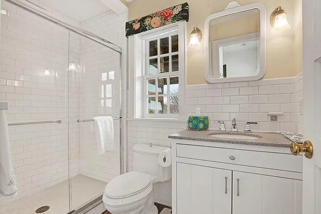 a bathroom with a sink toilet vanity and shower