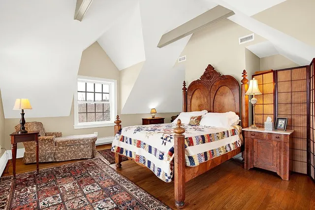 a bedroom with a bed wooden floor and window