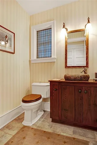 a bathroom with a granite countertop sink and a toilet