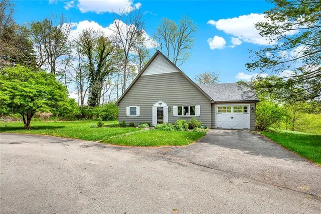 a view of a house with a yard and large trees