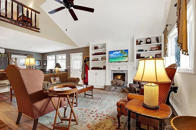 a living room with furniture a fireplace and a flat screen tv