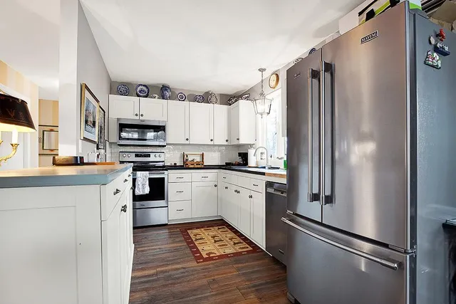 a kitchen with stainless steel appliances a refrigerator sink and microwave