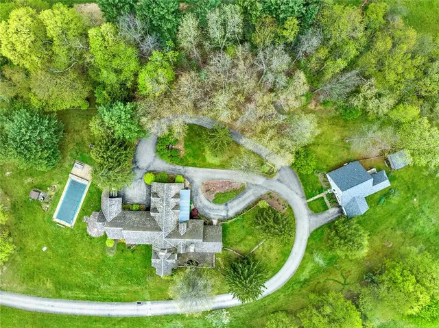 an aerial view of a house with swimming pool patio and fire pit