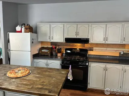 a kitchen with a refrigerator and a stove top oven