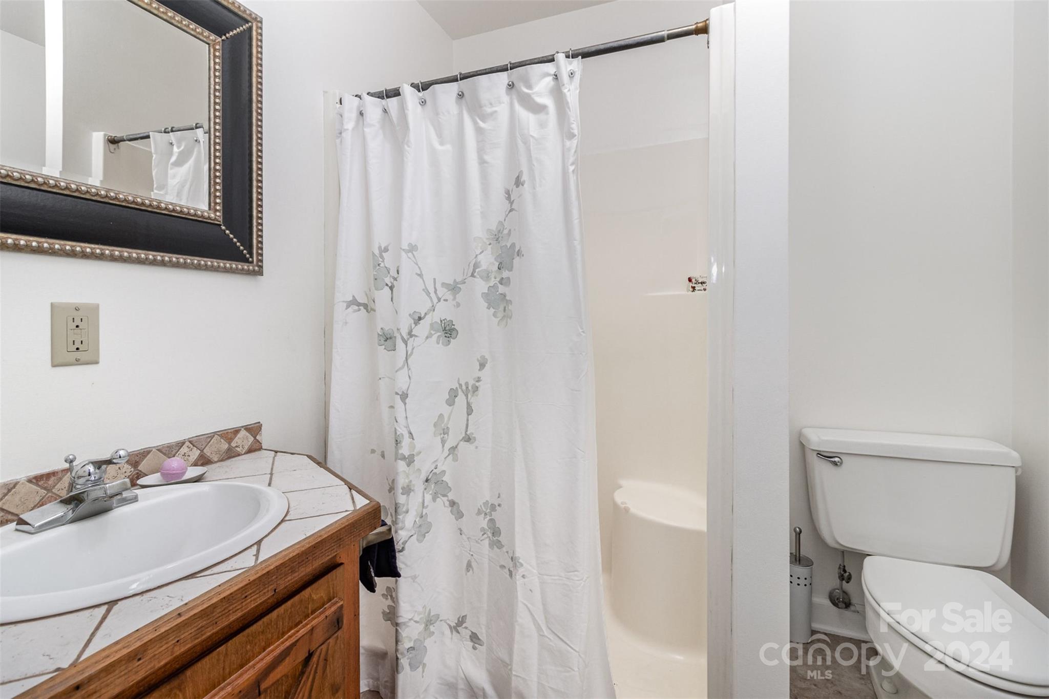 808 Dogwood Drive Lowell, NC 28098 - Photo 15 of 36 a bathroom with a sink a toilet and shower curtain