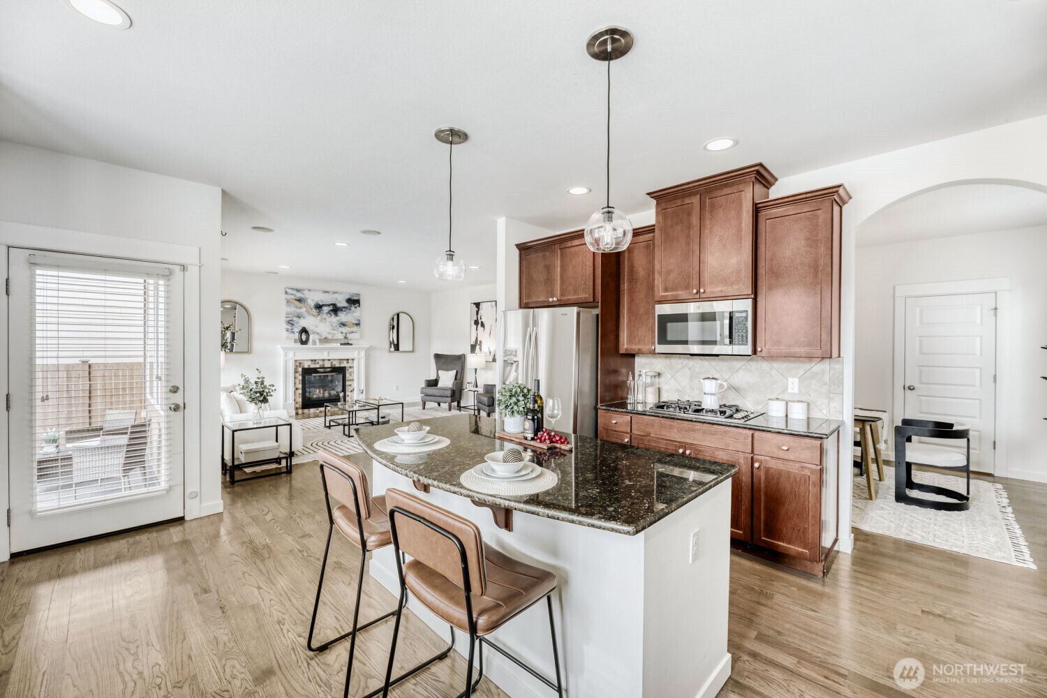 3626 222nd Place Southeast Bothell, WA 98021 - Photo 9 of 27 a kitchen with stainless steel appliances kitchen island granite countertop a refrigerator a stove and white cabinets with wooden floor