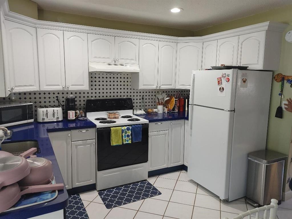 5004 Northwest 49th Road Tamarac, FL 33319 - Photo 3 of 16 a kitchen with stainless steel appliances a refrigerator sink and cabinets