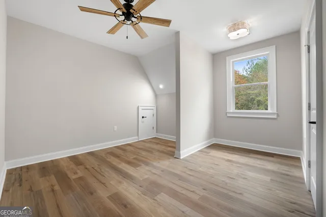 an empty room with wooden floor and window